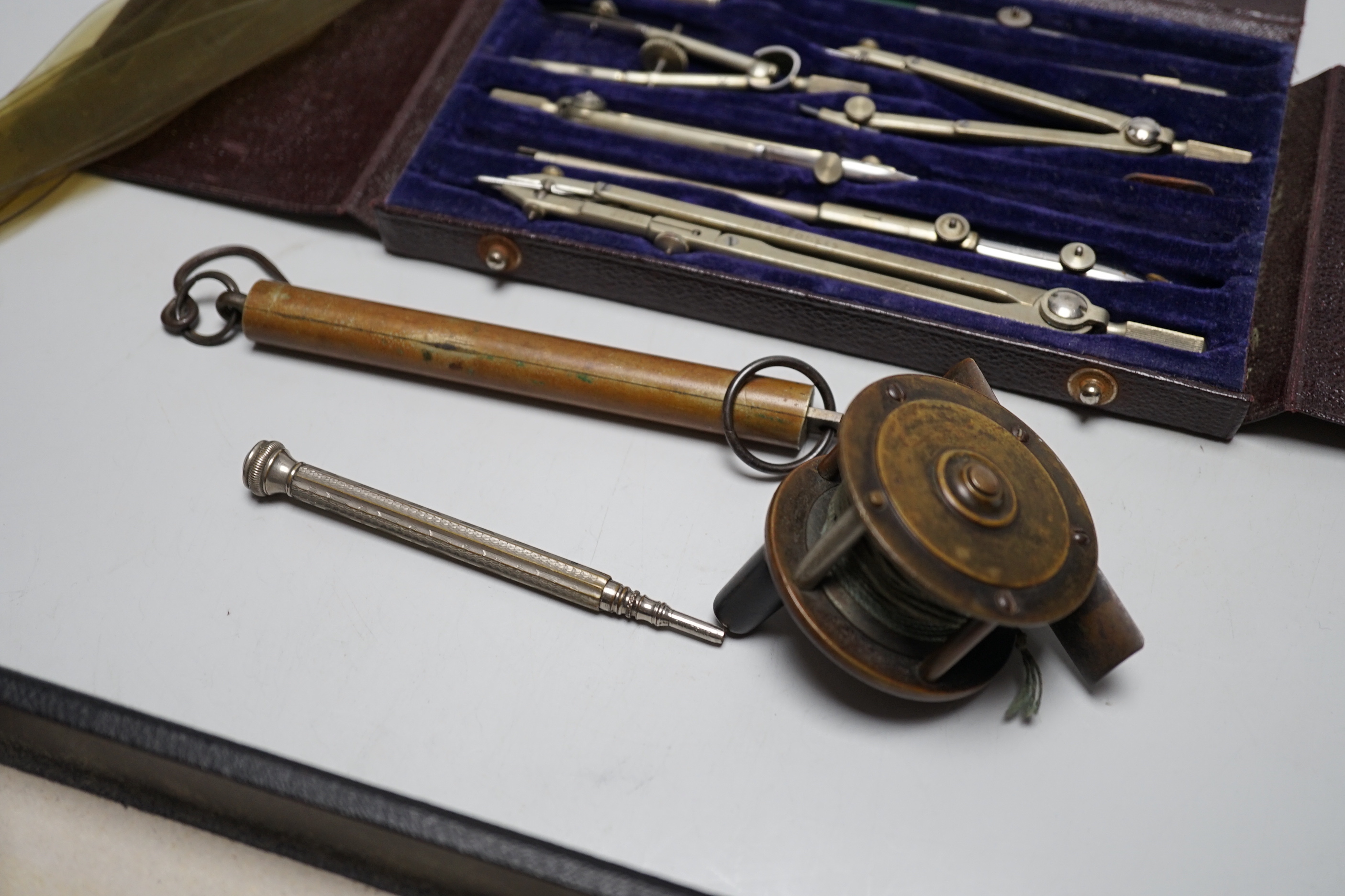 A mixed group of collectables including a commemorative bottle opener, shooting medallion, fishing reel etc.